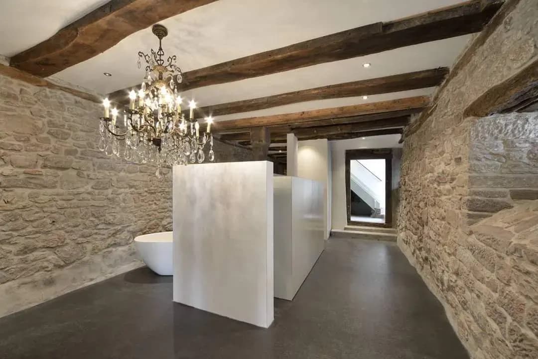 Historischer Raum mit Natursteinwänden und dunklem fugenlosem Bodenbelag von Mion AG
